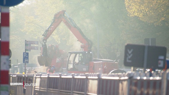 Im Nebelstaub einer Baustelle arbeitet ein Bagger an einer Straßenausbesserung. © Screenshot 