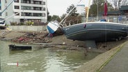 In einem kleineren Sportboothafen liegen Segelboote brach auf der Kairampe nach einem heftigen Sturm. © Screenshot 