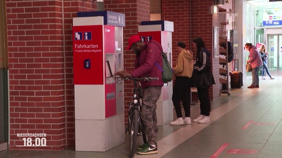 Menschen stehen an einem Fahrkartenautomat. © Screenshot 