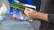 Ein Mann blättert durch das Kochbuch "Rute raus". © Screenshot 