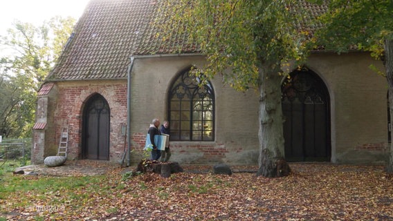 Zwei Personen laufen am Kloster St. Jürgen vorbei. © Screenshot 