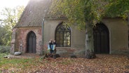 Zwei Personen laufen am Kloster St. Jürgen vorbei. © Screenshot 