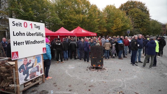 Arbeiter und Arbeiterinnen der FSG stehen auf einem Platz und protestieren. © Screenshot 