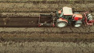 Eine Luftaufnahme eines landwirtschaftlich genutzten Feldes, über das ein Traktor fährt. © Screenshot 