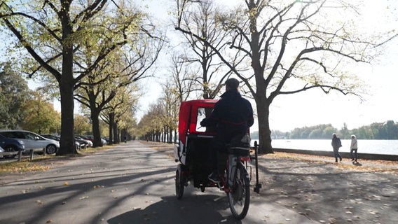 Eine Rikscha fährt entlang einer Straße. © Screenshot 