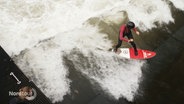 Eine Person surft auf einer stehenden Welle in einem Kanal. © Screenshot 