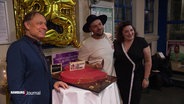 Saänger und Schirmherr der Hamburg School of Music posiert für ein Foto vor einem Kuchen in Herzform. © Screenshot 