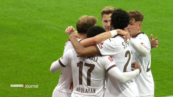 Spieler des FC St. Pauli fallen sich nach einem Treffer auf dem Spielfeld in die Arme. © Screenshot 