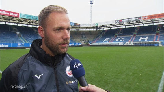 Hansa Rostocks neuer Coach Daniel Brinkmann spricht mit Reporter Jan Didjurgeit. © Screenshot 