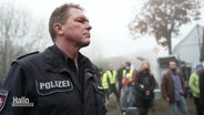 Polizist Thomas Engelhardt schaut mit kritischem Blick bei den Dreharbeiten eines Krimifilms zu. © Screenshot 