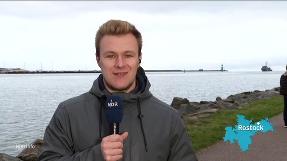 NDR-Reporter Dennis Mollenhauer steht am Rostocker Seekanal und berichtet. © Screenshot 