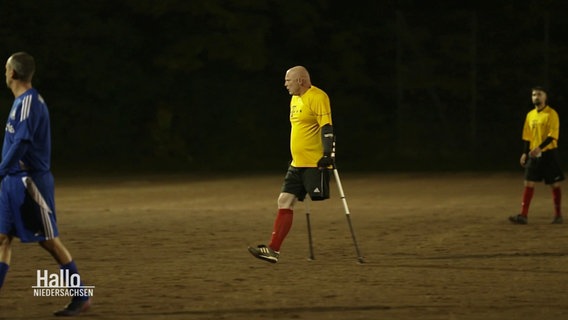 Ralf Stellfeld bewegt sich mit Gehhilfen auf dem Fußballplatz. © Screenshot 