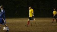 Ralf Stellfeld bewegt sich mit Gehhilfen auf dem Fußballplatz. © Screenshot 