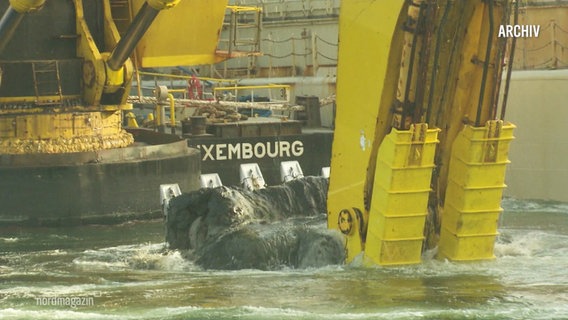 Ein schwimmender Spezialbagger bringt eine Schaufelladung Shclick an die Wasseroberfläche. © Screenshot 