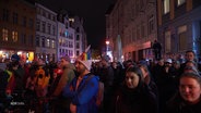 Viele Personen stehen in einer Straße und demonstrieren. © Screenshot 