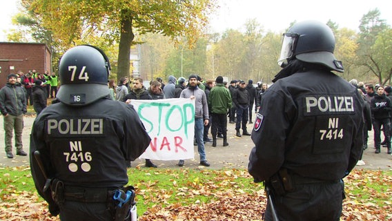 Polizisten sind von Hinten bei einer Art Demonstration zu sehen. © Screenshot 