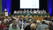 Redner und Publikum bei der Debatte beim Städte- und Gemeindetag in Güstrow. © Screenshot 