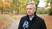 Screenshot: Sven Müller, Hauptgeschäftsführer im Arbeitgeberverband MV, steht in einem herbstlichen Park. © Screenshot 