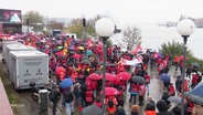 Demonstrierende der IG Metall bei Regen in Hamburg. © Screenshot 