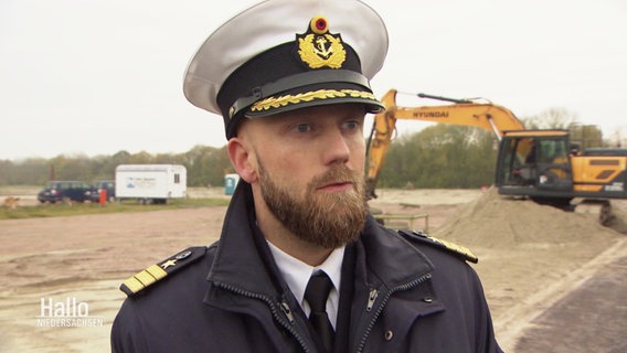 Kasernenkommandant Robert Falkner steht vor der Baustelle der Marinebasiserweiterung in Wilhelmshaven. © Screenshot 