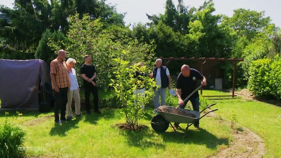 In einem Garten wird eine Magnolie gepflanzt. © Screenshot 