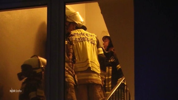 Feuerwehrleute und Rettungssanitäter stehen in einem Treppenhaus. © Screenshot 