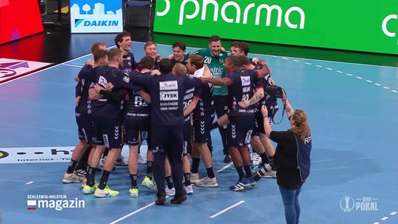 Die Flensburger Handballer stehen im Kreis zusammen und freuen sich. © Screenshot 