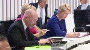 Ministerpräsidentin Manuela Schwesig sitzt neben zwei Politikern im Landtag. © Screenshot 