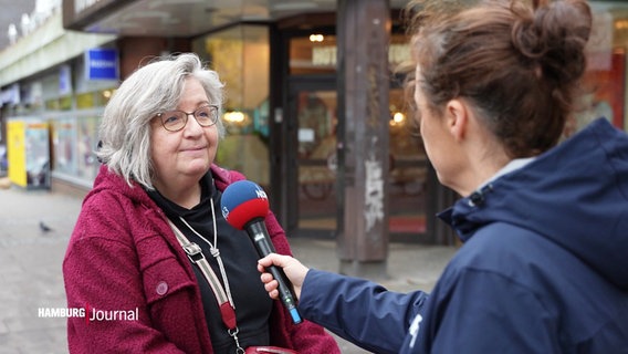 Eine Frau wird von einer Straßenreporterin interviewt. © Screenshot 