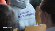 Jemand trägt einen grauen Pulli mit der violetten Aufschrift: Zukunft made in Europe. © Screenshot 