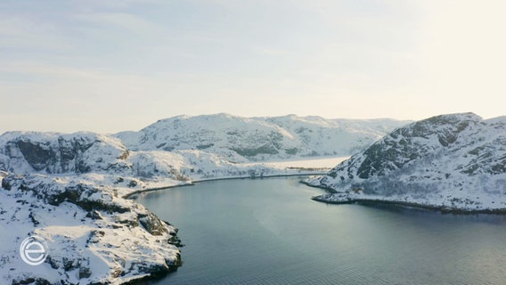 Ein winterlicher Fjord wird von schneebedeckten Hügeln eingerahmt. © Screenshot 