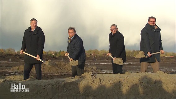 Gesundheitsminister Philippi und drei weitere Personen eröffnen mit dem ersten Spatenstich den Bau des neuen Zentralkrankenhauses in Ostfriesland. © Screenshot 