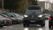 Ein fahrender, schwarzer Minibus von VW mit der Aufschrift "Self-driving-vehicle". © Screenshot 