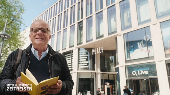 Hubertus Meyer-Burckhardt ist mit einem historischen Reiseführer in Hamburg unterwegs. © Screenshot 