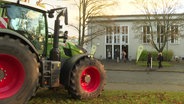 Ein Traktor steht vor dem Eingang zur "Young Farmers Convention". © Screenshot 