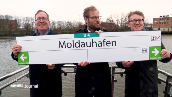 Drei Vertreter der Stadt halten ein Schild mit der Aufschrift "U4 Moldauhafen". © Screenshot 