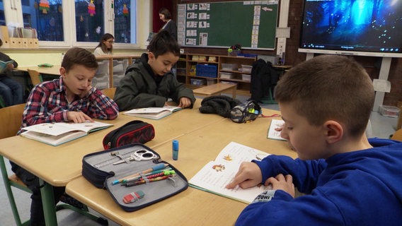 Kinder arbeiten in einer Schulklasse an Gruppen-Tischen. © NDR 