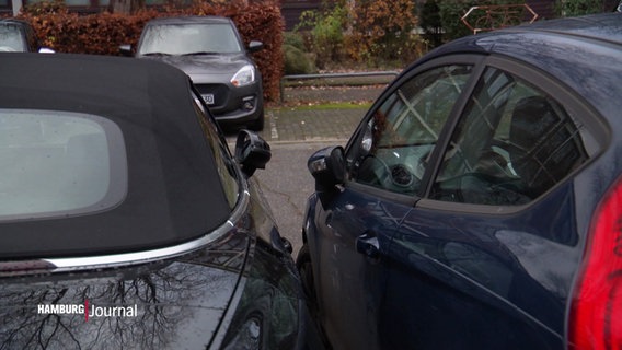 Zwei Autos stehen auf einem Parkplatz dicht beieinander. © Screenshot 