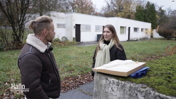 Ein Reporter spricht mit einer Studentin über ihren Architekturentwurf. © Screenshot 