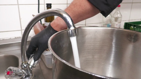 In einem Restaurant auf Fehmarn wird Wasser zum Abkochen in einen Topf gefüllt. © Screenshot 