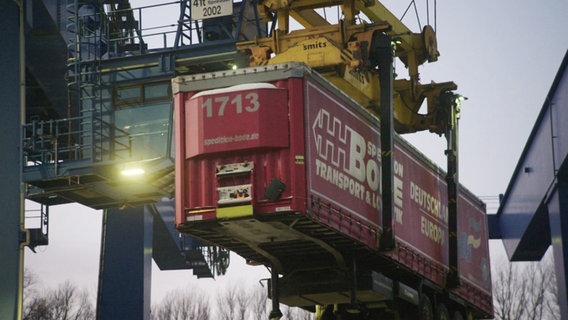 Am Port of Lübeck wird ein Container mit einem Kran transportiert. © Screenshot 