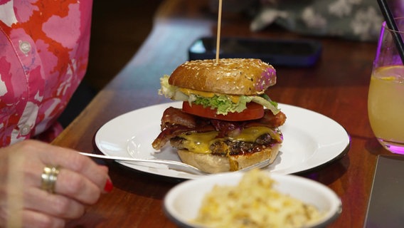 Ein Hamburger, serviert auf einem Teller. © Screenshot 