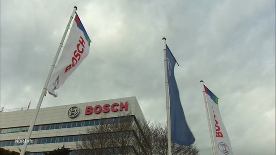 Gebäude der Firma Bosch sowie flatternde Fahnen mit dem Firmenlogo im Vordergrund. © Screenshot 