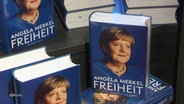 Mehrere Exemplare von Merkels Memoiren stehen in der Auslage eines Buchladens. © Screenshot 