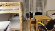 Ein Zimmer mit Doppelstockbetten in einer Geflüchtetenunterkunft © Screenshot 