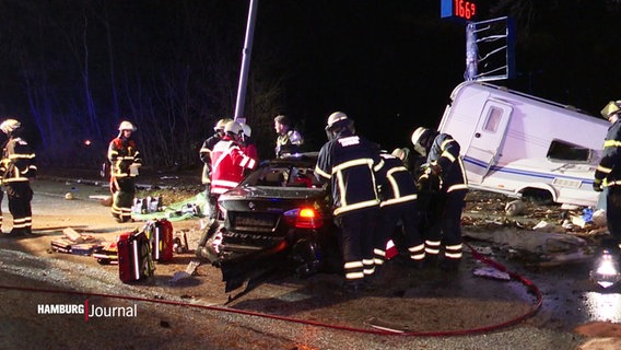 Feuerwehrleute bei einem durch einen Unfall beschädigten Wagen. © Screenshot 