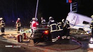 Feuerwehrleute bei einem durch einen Unfall beschädigten Wagen. © Screenshot 