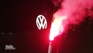 Ein rotes Bengalo-Feuerwerk, im Hintergrund das VW-Logo. © Screenshot 