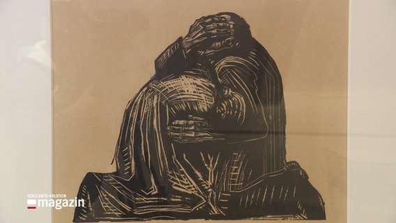 Holzschnitt von Käthe Kollwitz von 1921 mit dem Titel "Die Eltern": Zwei ineinander geschlungene Körper, wo einer sich auf den anderen stützt. Ihre Gewänder sind schwarz. Die männliche Figur hält sich die große Hand vors Gesicht, die Frau hat ihren gesenkten Kopf im Arm des Mannes versunken. © Screenshot 