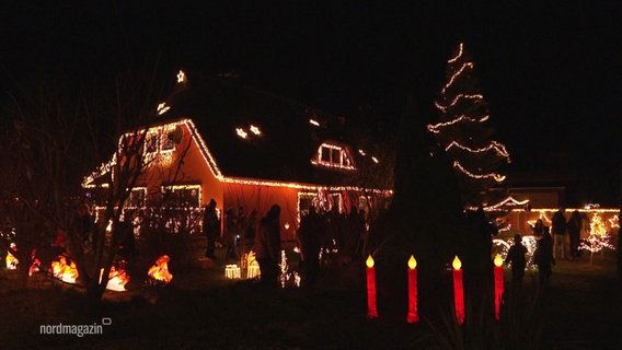 Ein mit weihnachtlichen Lichtern geschmücktes Haus und Grundstück. © Screenshot 